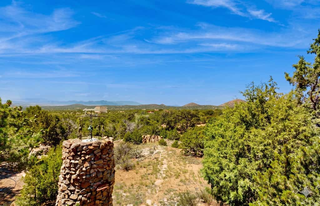 Welcome to Casa de las Piedras, a one-of-a-kind Pueblo-style retreat tucked into the hills outside Santa Fe. Surrounded by high-desert beauty and sweeping mountain and valley views, this rustic 2-bedroom home is filled with regional art, vigas, and Southwestern charm. Watch golden sunsets from the stone terrace, gather for meals in the gazebo, and step out your door onto hiking trails, with downtown Santa Fe just a short drive away.