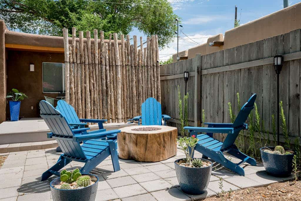 Welcome to Santa Fe Serenity, a light-filled home tucked behind private adobe walls just a short walk from the Railyard District. Step inside to warm terracotta tile, skylights, and a cozy living room anchored by a wood stove, then gather around the dining table or cook in the fully equipped kitchen. Two queen bedrooms with ceiling fans and hardwood floors make it easy to settle in, while the walled backyard, with its covered deck, fire feature, and flourishing garden of raised beds and fruit trees, invites slow mornings and golden-hour evenings. Minutes from the Plaza, world-class museums, and Santa Fe's celebrated food scene, this dog-friendly, 1,005 sq ft retreat is the perfect base for exploring the City Different.