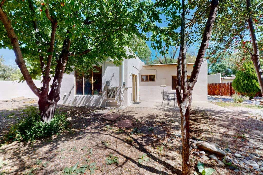 Welcome to Casa Belleza, a sunlit Southwestern adobe tucked on a quiet cul-de-sac near Taos. Gather in the open living space around the kiva-style fireplace, cook in a cheerful turquoise kitchen, and step out to a fully fenced, tree-shaded yard your dog will love. With two queen bedrooms, mini-split AC, and a covered portal for easy evenings, this single-level home is a relaxed, pet-friendly base for galleries, the Plaza, and Taos adventures.