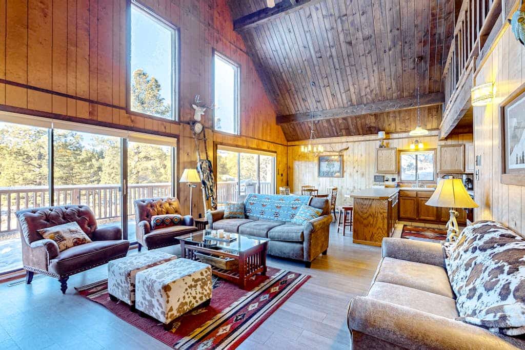 Welcome to Casa Buena Vista, a warm chalet-style cabin tucked among the pines of Angel Fire. A soaring vaulted great room with a stone wood-burning stove and walls of windows invites your group to gather after a day outdoors. Two king bedrooms plus an open loft sleep eight, and the wraparound deck with a gas grill is made for slow mountain mornings. Bring the dog and settle in for ski days, summer hikes, or a quiet reset in the trees.
