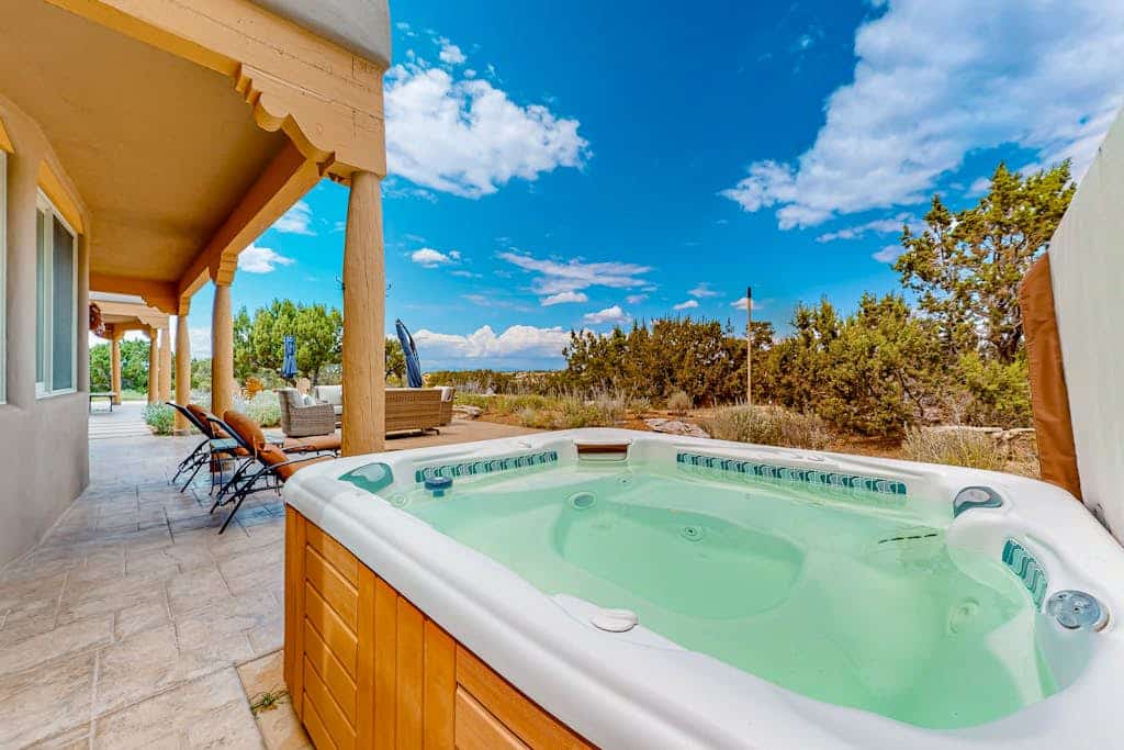 Welcome to Dos Vistas, a single-level adobe retreat set on a quiet stretch of high desert just outside Santa Fe. Sip sunrise coffee with the Sandia Mountains on the horizon, spend the day exploring galleries and trails, then watch the Sangre de Cristos glow at sunset from the private hot tub. With viga ceilings, two kiva fireplaces, a chef's kitchen, and wide patios for grilling and stargazing, this is your basecamp for the best of Northern New Mexico.