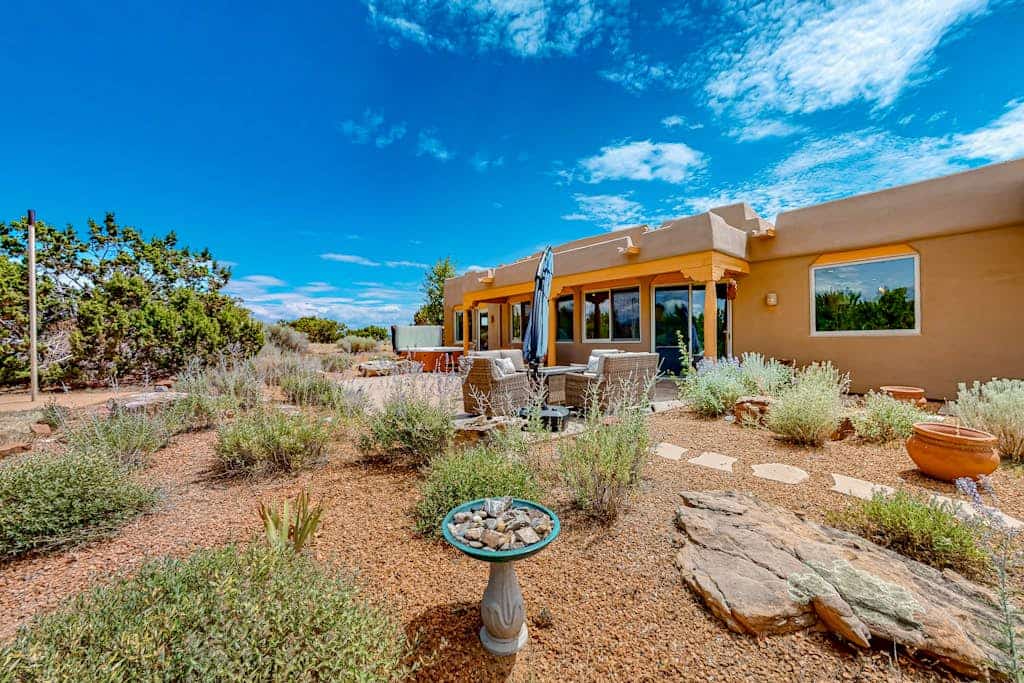 Welcome to Dos Vistas, a single-level adobe retreat set on a quiet stretch of high desert just outside Santa Fe. Sip sunrise coffee with the Sandia Mountains on the horizon, spend the day exploring galleries and trails, then watch the Sangre de Cristos glow at sunset from the private hot tub. With viga ceilings, two kiva fireplaces, a chef's kitchen, and wide patios for grilling and stargazing, this is your basecamp for the best of Northern New Mexico.
