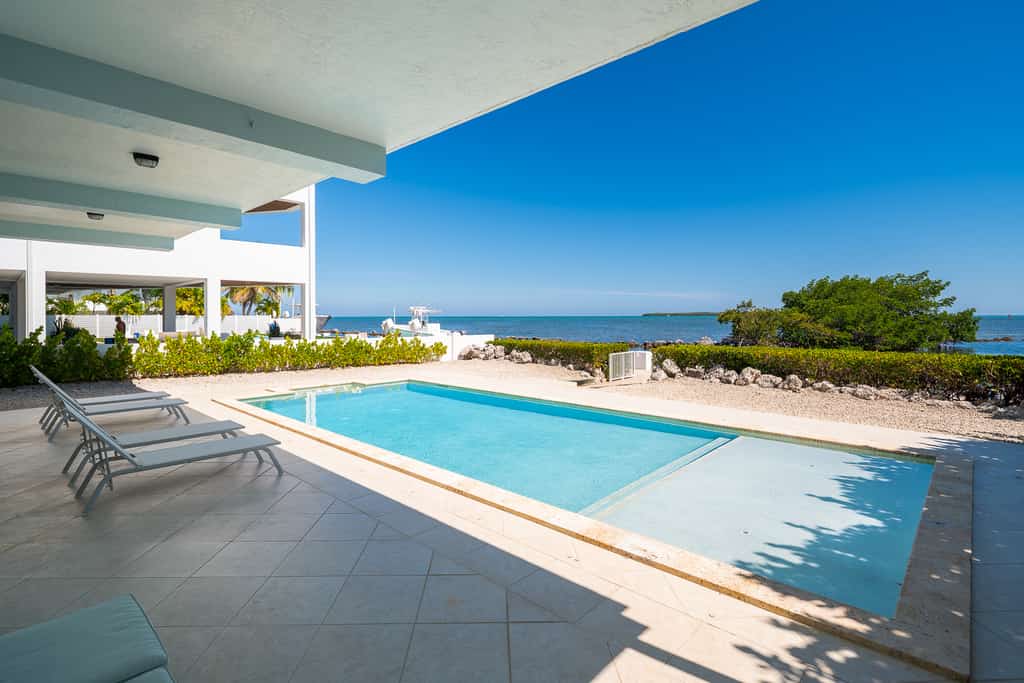 Oceanfront home with a pool, dock, grill, scenic balconies, games, W/D, & AC