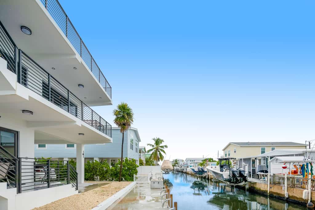 Modern canal-front home with a rooftop deck, open-concept interior, AC, & W/D
