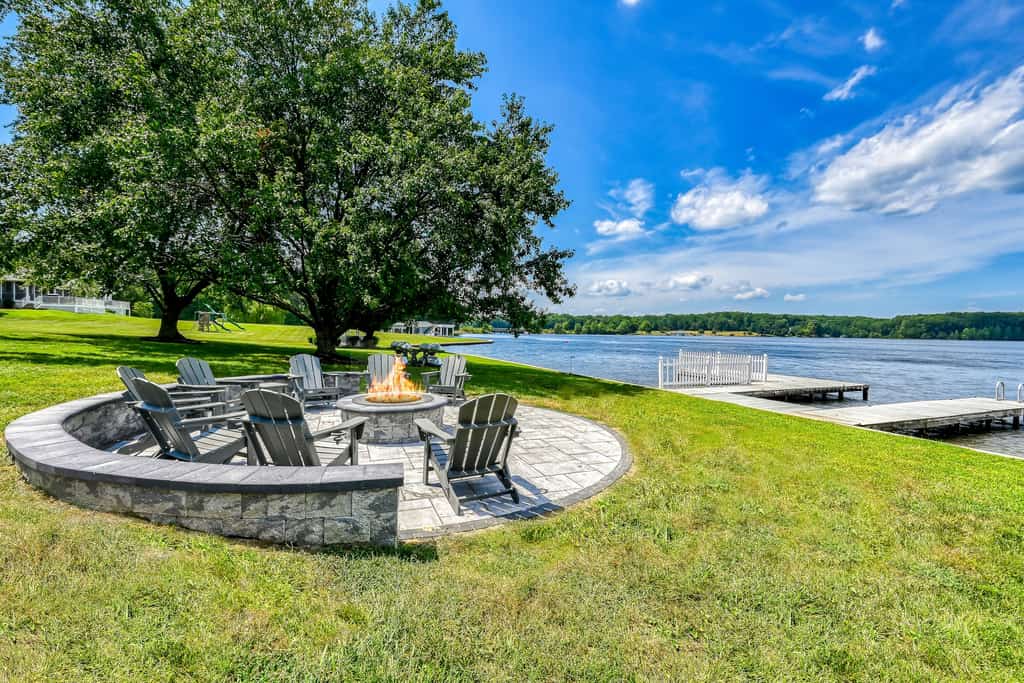 Lakefront retreat with a large yard, stone fire pit, gazebo, deck, & dock