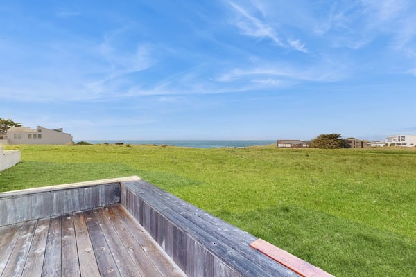 Unobstructed ocean views across a green coastal meadow -- the Pacific stretches to the horizon from your deck. Settle in by the floor-to-ceiling stone fireplace and watch the light change all day. Bring your pup -- dogs love the bluff trails here. Room for 4 in this 2-bedroom home. Sea Ranch community pools, tennis courts, and the Lodge are nearby. A private fenced courtyard with a gas grill makes sunset dinners easy. The ever-changing coastal light fills this home from morning fog to golden evening.