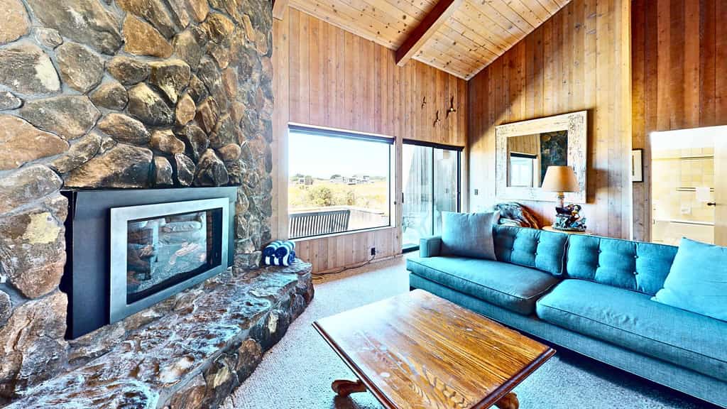 Unobstructed ocean views across a green coastal meadow -- the Pacific stretches to the horizon from your deck. Settle in by the floor-to-ceiling stone fireplace and watch the light change all day. Bring your pup -- dogs love the bluff trails here. Room for 4 in this 2-bedroom home. Sea Ranch community pools, tennis courts, and the Lodge are nearby. A private fenced courtyard with a gas grill makes sunset dinners easy. The ever-changing coastal light fills this home from morning fog to golden evening.
