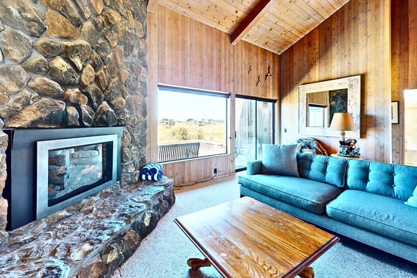 Unobstructed ocean views across a green coastal meadow -- the Pacific stretches to the horizon from your deck. Settle in by the floor-to-ceiling stone fireplace and watch the light change all day. Bring your pup -- dogs love the bluff trails here. Room for 4 in this 2-bedroom home. Sea Ranch community pools, tennis courts, and the Lodge are nearby. A private fenced courtyard with a gas grill makes sunset dinners easy. The ever-changing coastal light fills this home from morning fog to golden evening.