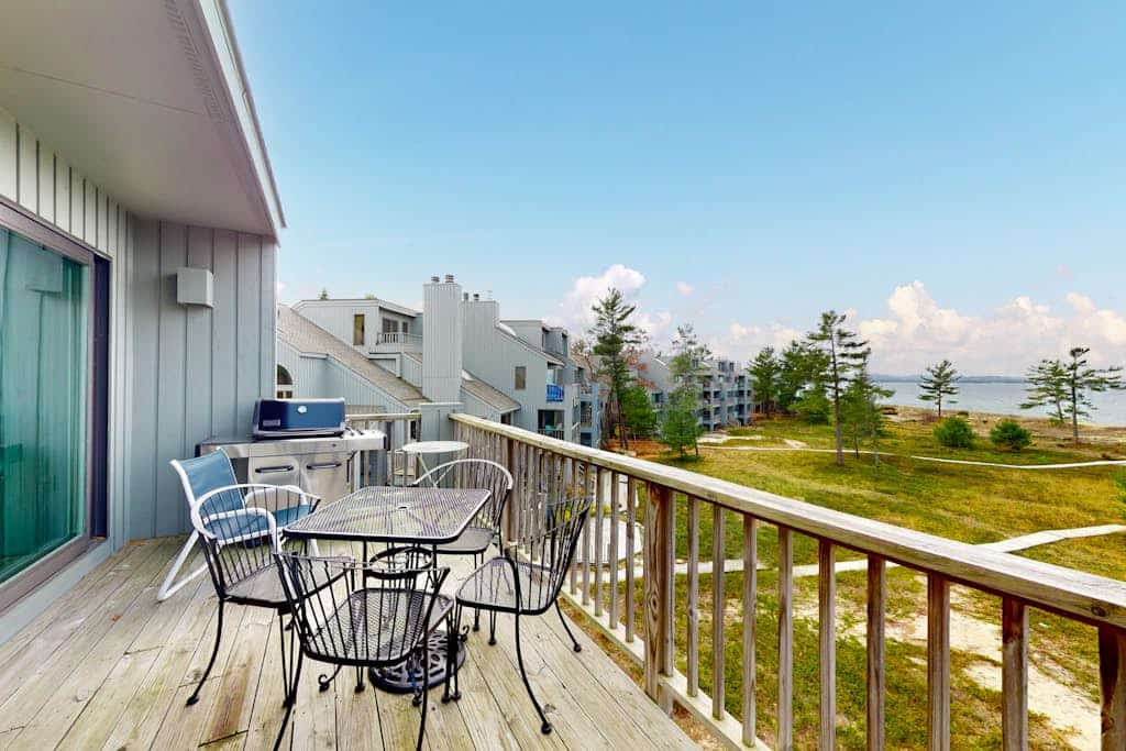 Sunny upper-level beachfront condo with Lake Michigan views, fireplace, deck