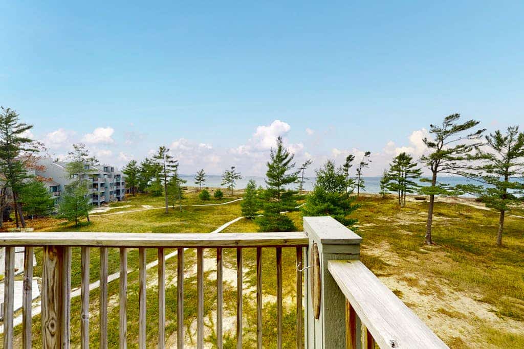 Sunny upper-level beachfront condo with Lake Michigan views, fireplace, deck