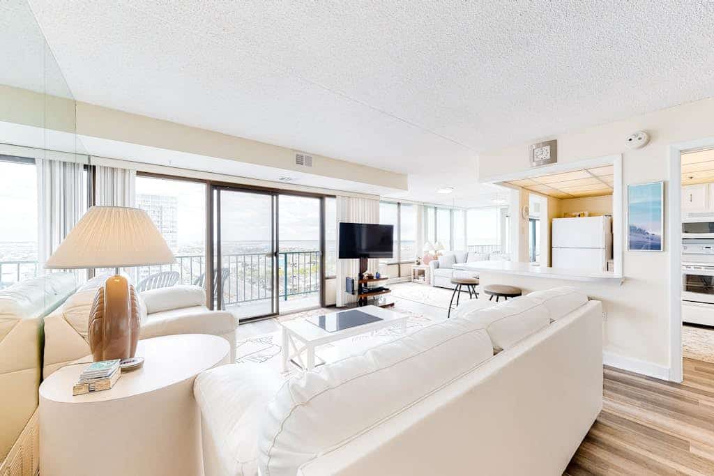 Bright coastal condo with pool access, side views of the ocean, balcony & W/D
