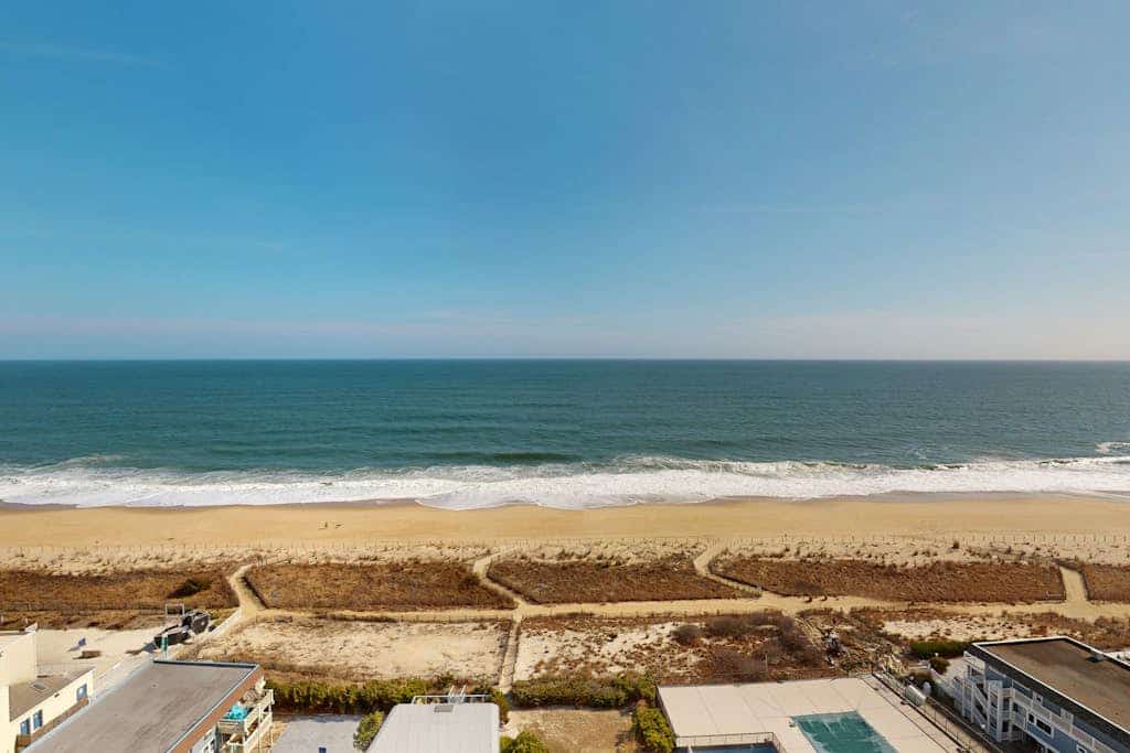 Beachfront condo with outdoor pool, bay & sunset views, large balcony, & tennis