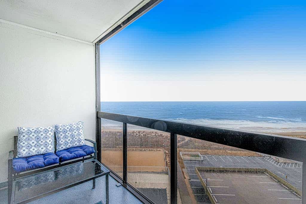 Convenient beachfront condo with angled views, cozy balcony, pools, gym & tennis