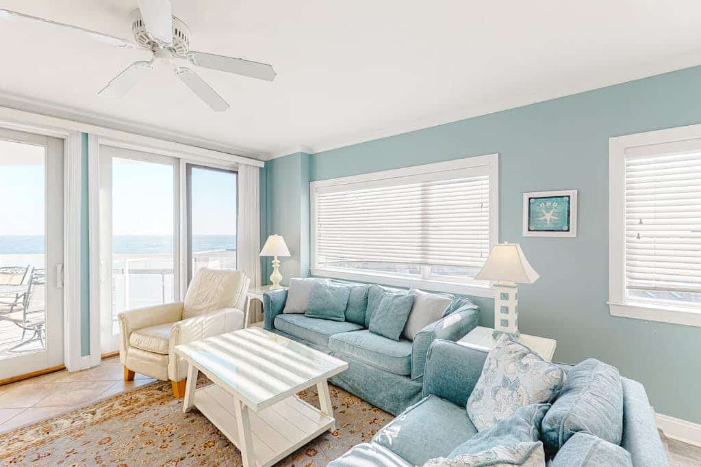 Ocean-view condo with shaded balcony, central AC, W/D, pool, gym & coastal decor