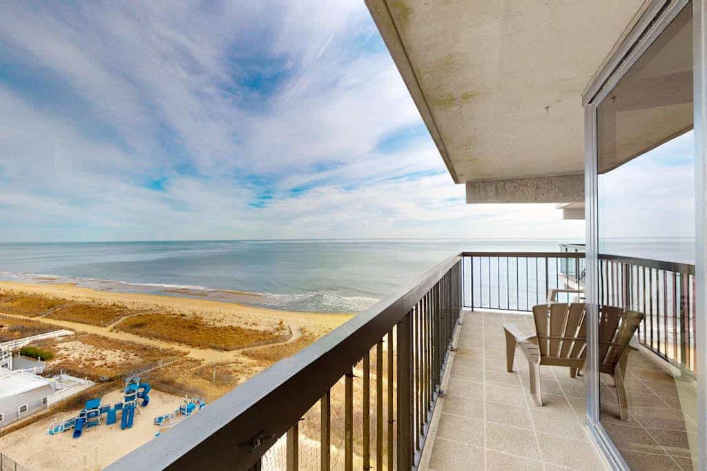 Beachfront condo with wrap-around balcony, modern interior, pools, & gym