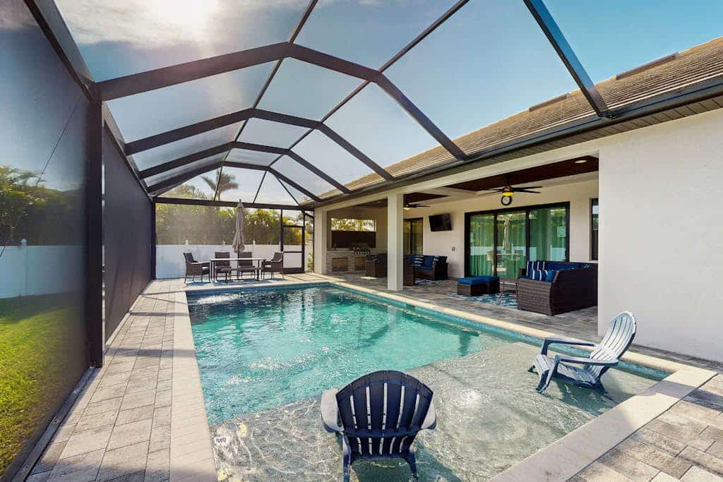 Modern canal-front luxury with pool, patio, grill, dock, Ping-Pong, AC, & WiFi