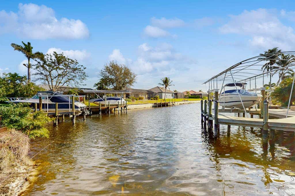 Modern canal-front luxury with pool, patio, grill, dock, Ping-Pong, AC, & WiFi