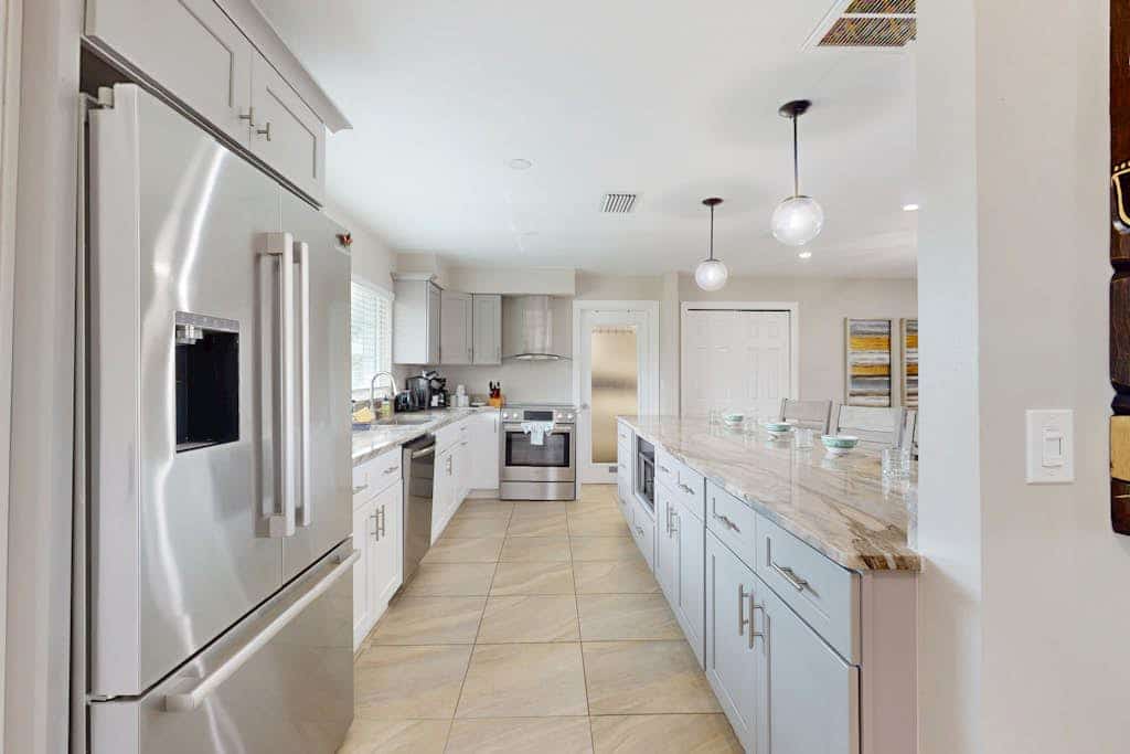 Canal-front home with screened pool, dock access, patio, grill, AC, & W/D