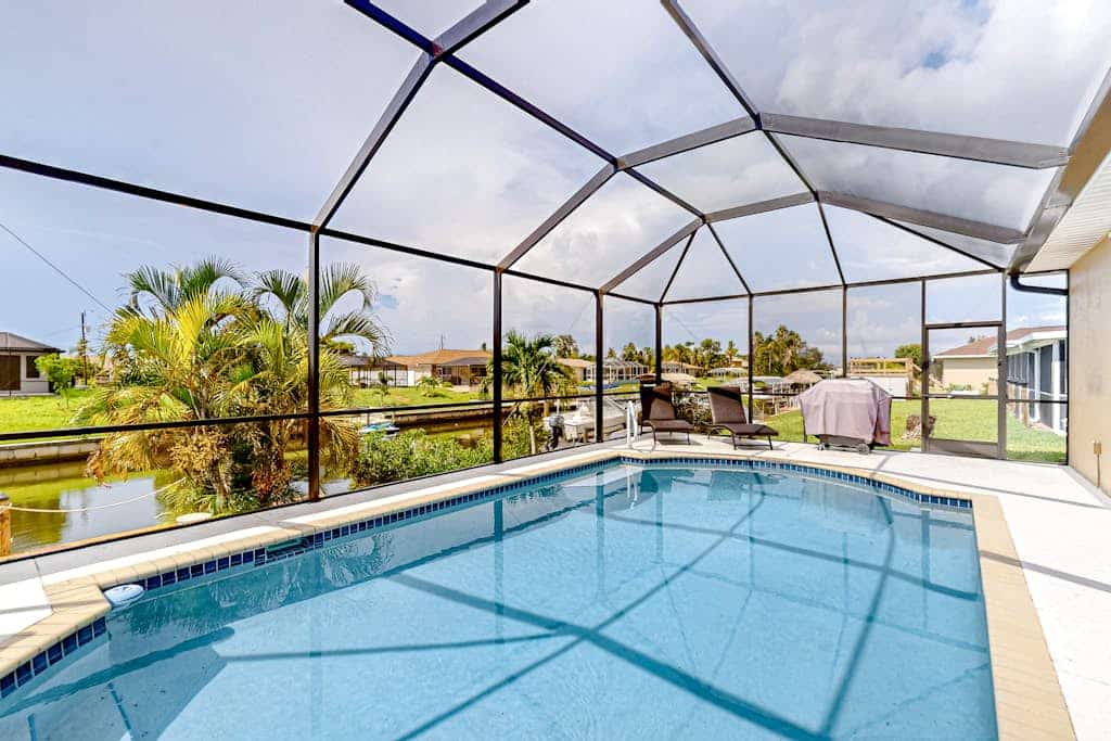 Waterfront home with screened pool, patio, grill, foosball, AC, & W/D
