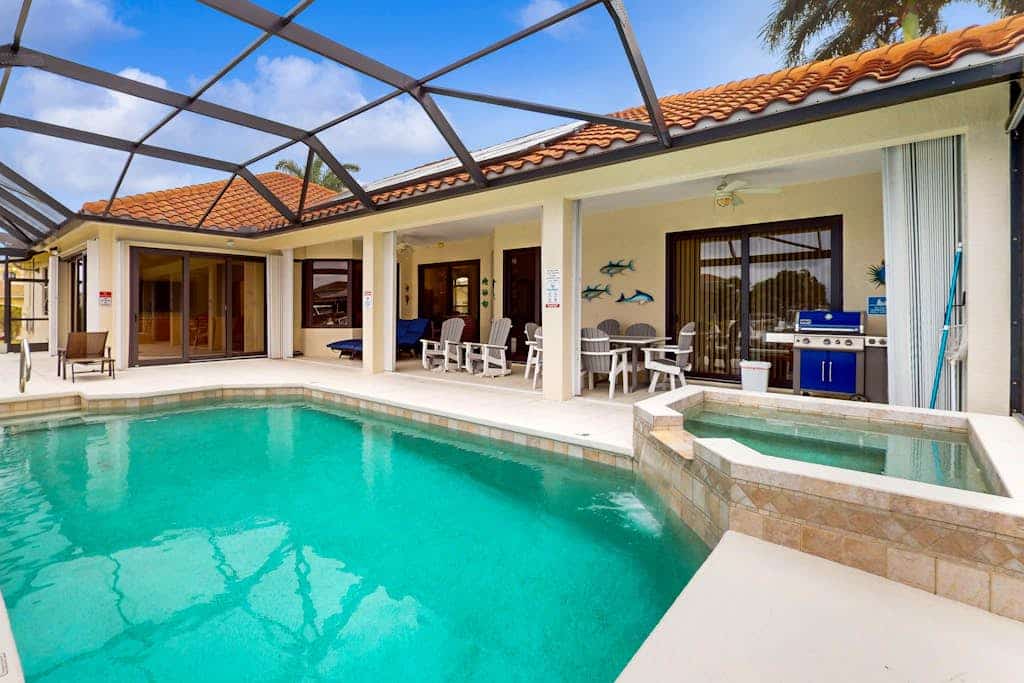 Canal-front home with private pool, pool spa, dock, boat access, grill, gym, W/D