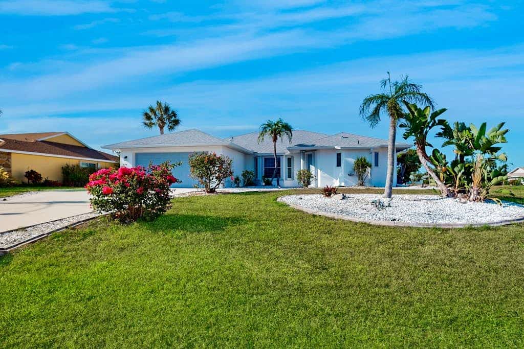 Palm-lined waterfront retreat with enclosed pool, inviting patio, & central AC