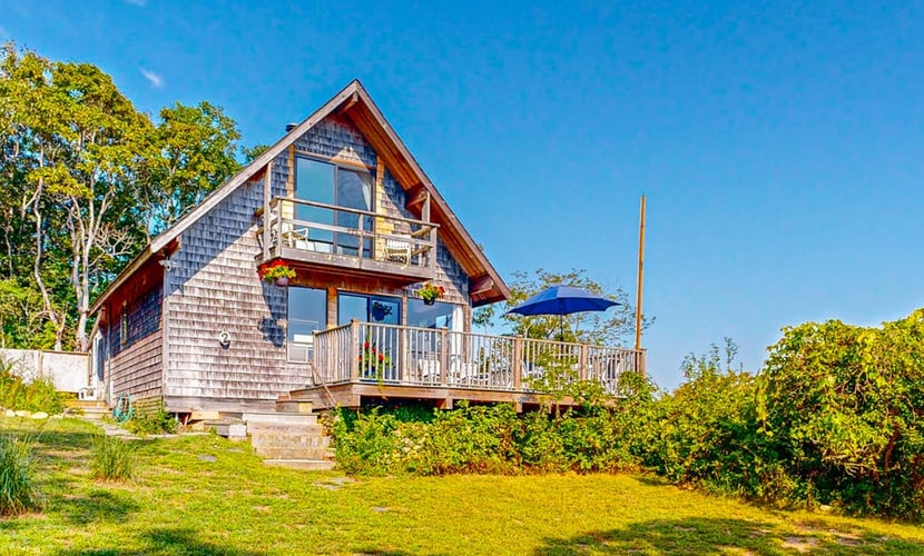 Water-view home with large deck, balcony, enclosed sunroom & peaceful location