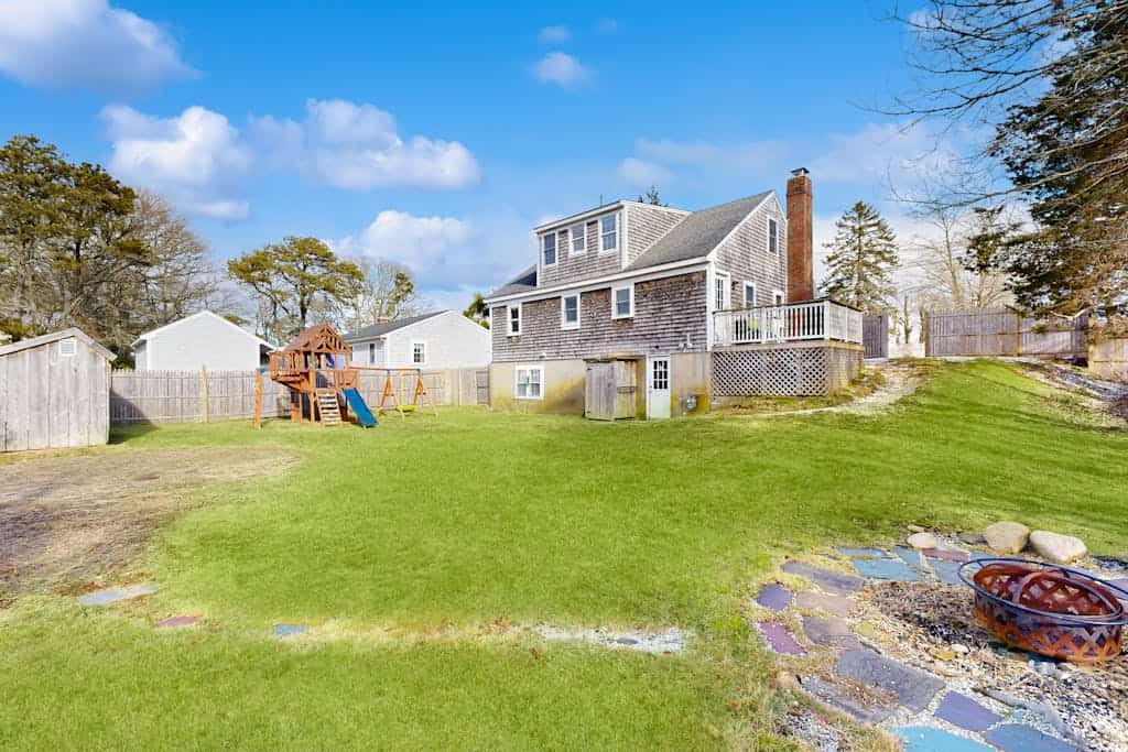 Two-story dog-friendly retreat with enclosed yard, playset, W/D, & firepit