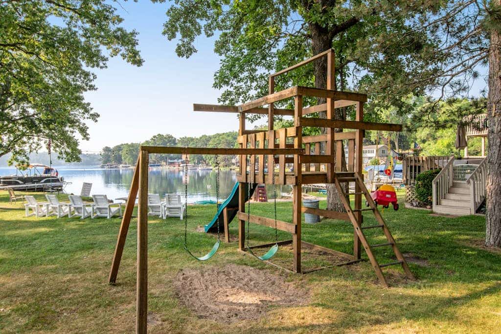 Lakefront condo with beach access, firepit, games, fireplace, & dock