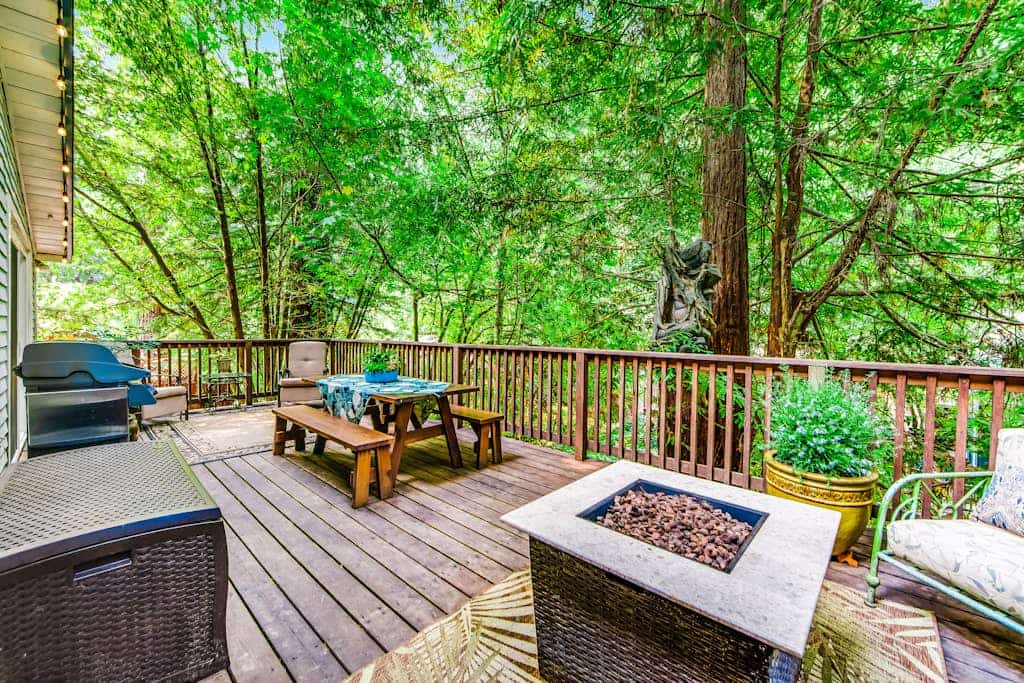 Sip morning coffee on the deck as redwood light filters through the canopy, your pup exploring the wooded yard below. This 2-bedroom Guerneville cottage sleeps 5 with a gas fireplace for cool evenings, a front balcony, and a fire pit out back. Saucy Mama's soul food sits 0.6 miles away, Armstrong Redwoods 2.5 miles up the road, and the Russian River runs just minutes from the door.