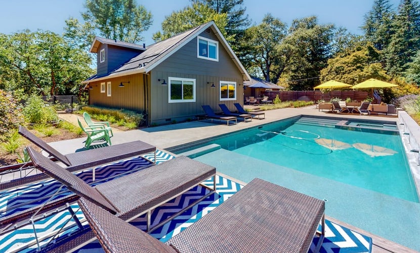 Sunlight streams through tall windows onto exposed wood beams and dark hardwood floors — this is modern wine country living with room to breathe. Four bedrooms, a pool, hot tub, and fire pit spread across landscaped grounds surrounded by mature trees, all just a five-minute drive from Sonoma Plaza and its 20-plus walkable tasting rooms. Buena Vista Winery and Gundlach Bundschu are each about a mile away. Gather your group and settle into Sonoma Valley the way it was meant to be.