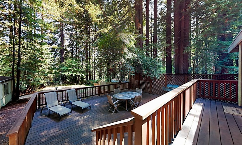 Soak in the deck hot tub as redwoods tower around this Cazadero retreat. Inside, knotty pine cabinets meet dark granite at the U-shaped kitchen, and a black wood stove warms the open living room. Walk forest paths 0.7 miles to Point of ridge, or 1.5 miles to Cape Fear Café. Dogs welcome.
