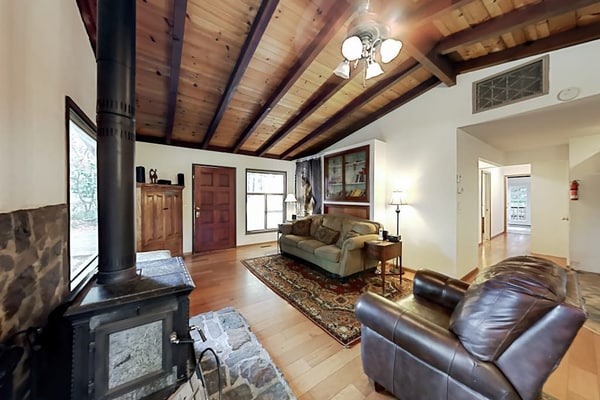 Soak in the deck hot tub as redwoods tower around this Cazadero retreat. Inside, knotty pine cabinets meet dark granite at the U-shaped kitchen, and a black wood stove warms the open living room. Walk forest paths 0.7 miles to Point of ridge, or 1.5 miles to Cape Fear Café. Dogs welcome.