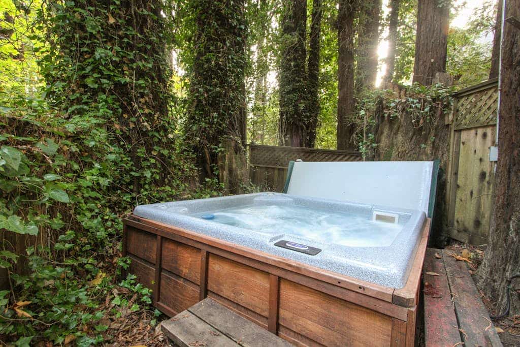 Wake to redwood light filtering across the deck of this dog-friendly cabin, a 3-minute walk from the neighborhood beach on the Russian River and 0.6 miles from downtown Guerneville. Soak in the private hot tub under the canopy, then warm up by the wood-burning fireplace inside. Two bedrooms and a twin sleep up to 5 in original clear-heart redwood rooms.