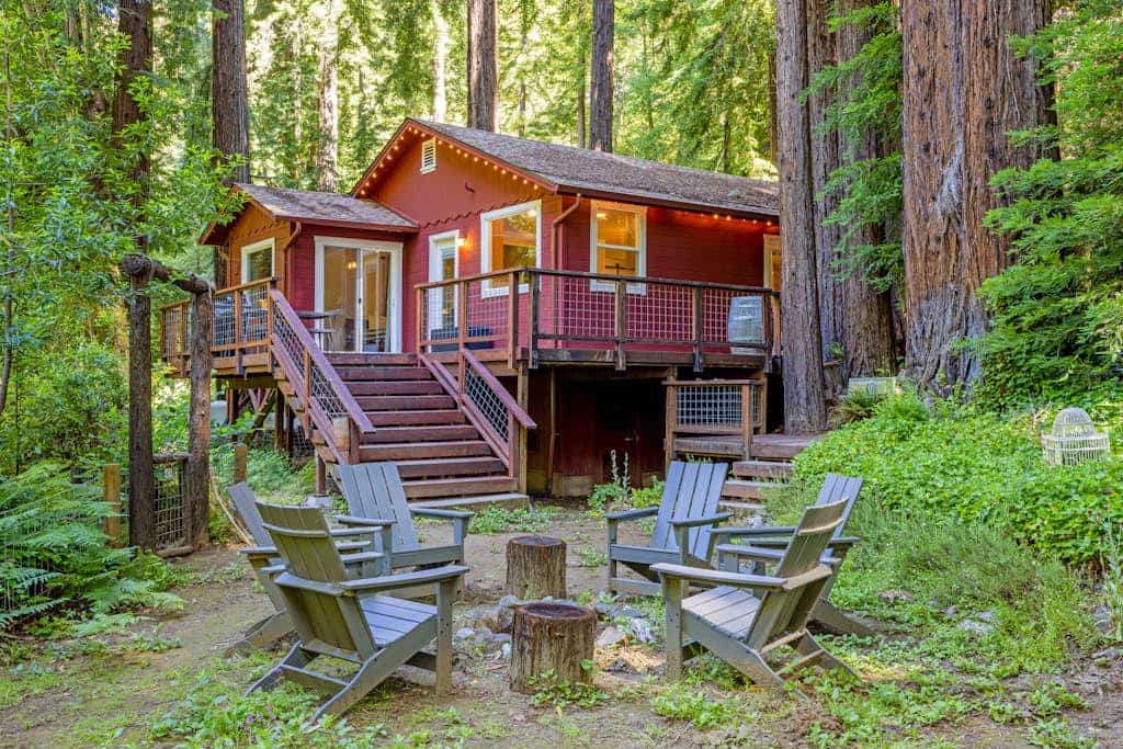 Step out the cabin door as redwoods tower over the wire-mesh deck of this Cazadero retreat. A blonde-wood accent wall anchors the open living room, the light-wood kitchen meets a white subway-tile backsplash, and a path from the back door leads down to Austin Creek. Walk 1.9 miles to Point of ridge, or 1.8 miles to the Cazadero General Store.