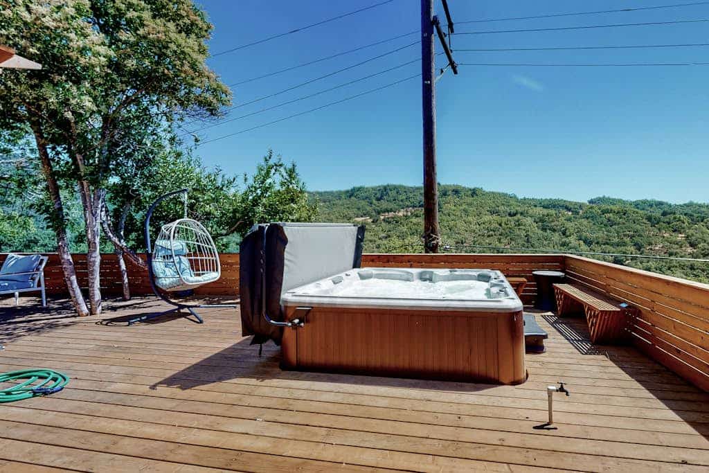 Soak in the Rooster-side hot tub as the Russian River Valley fades into sunset; the next morning, gather your crew on the Dragon-side rooftop deck for coffee in the treetops. Two 1940s Camp Rose cottages share this Fitch Mountain hillside, knit together as one whole-cabin stay — 7 bedrooms, two stone fireplaces, two kitchens, sleeps 16. Half a mile to the river beach; two miles to Healdsburg Plaza, SingleThread, and Valette.