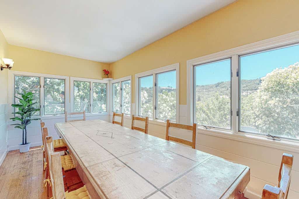 Soak in the Rooster-side hot tub as the Russian River Valley fades into sunset; the next morning, gather your crew on the Dragon-side rooftop deck for coffee in the treetops. Two 1940s Camp Rose cottages share this Fitch Mountain hillside, knit together as one whole-cabin stay — 7 bedrooms, two stone fireplaces, two kitchens, sleeps 16. Half a mile to the river beach; two miles to Healdsburg Plaza, SingleThread, and Valette.