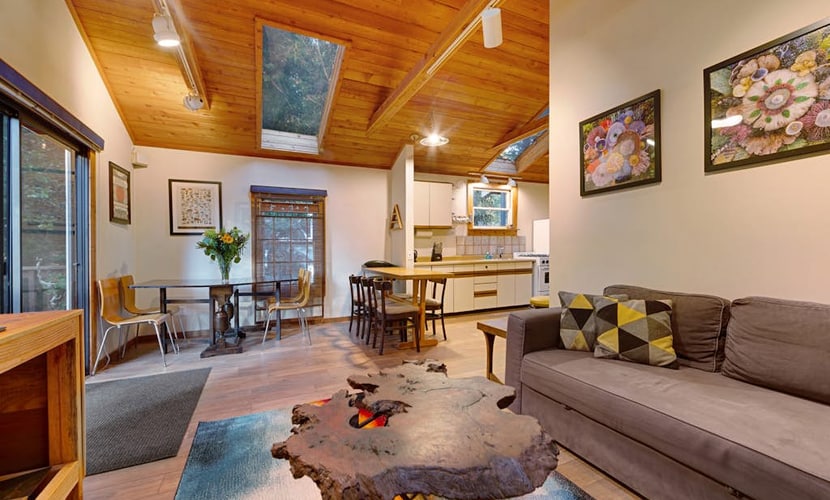 A stone hearth with a wood burning stove anchors this peaceful forest hideaway, where towering redwoods shade every window. Gather around the stone fireplace or grill dinner on the deck while kids play in the enclosed yard — this 2-bedroom cottage sleeps 4 comfortably. Just a 5-minute walk to a community beach with river access and a mile from Lightwave Coffee. Your days here move at redwood pace — slow, grounded, and deeply restorative among these ancient giants.