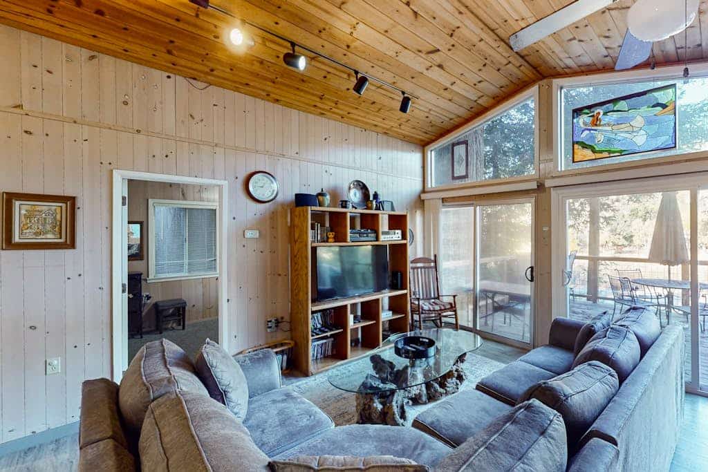Sunlight filters through towering redwoods as you sip morning coffee on the wraparound deck overlooking the Russian River. This dog-friendly retreat sleeps 8 with three bedrooms and an impressive outdoor kitchen complete with dual grills and smoker. Your private neighborhood beach sits right in the backyard — launch kayaks or simply wade into the gentle current. Just 5 minutes from downtown Guerneville's restaurants and 2 miles to Armstrong Redwoods. The river calls, and your cabin awaits.