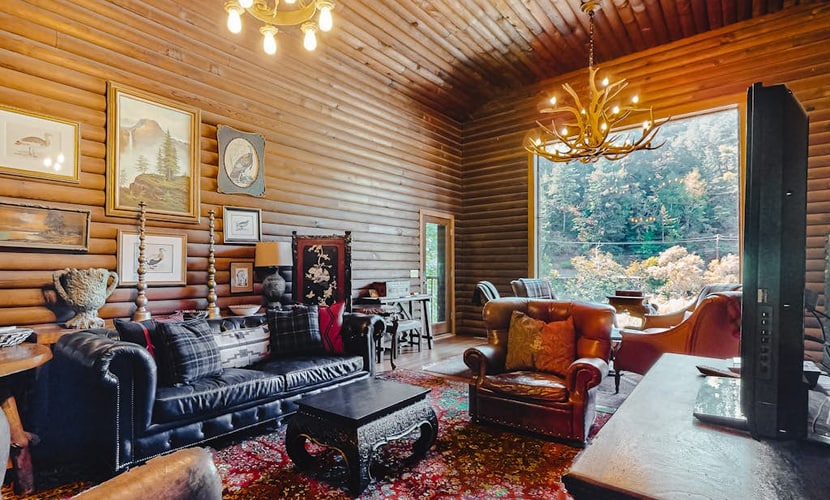 Sunlight filters through towering redwoods onto the private hot tub where you'll soak after floating the Russian River. This 1930s log lodge sleeps 10 with room for your dogs to roam the enclosed yard. Step through the 11-foot picture window view to your private river beach — one of the best fishing holes in Guerneville. Just 0.2 miles from The Lodge at Dawn Ranch and 0.3 miles from downtown's taco trucks and cafes.