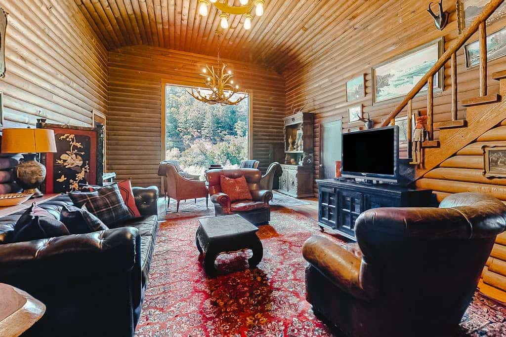Sunlight filters through towering redwoods onto the private hot tub where you'll soak after floating the Russian River. This 1930s log lodge sleeps 10 with room for your dogs to roam the enclosed yard. Step through the 11-foot picture window view to your private river beach — one of the best fishing holes in Guerneville. Just 0.2 miles from The Lodge at Dawn Ranch and 0.3 miles from downtown's taco trucks and cafes.