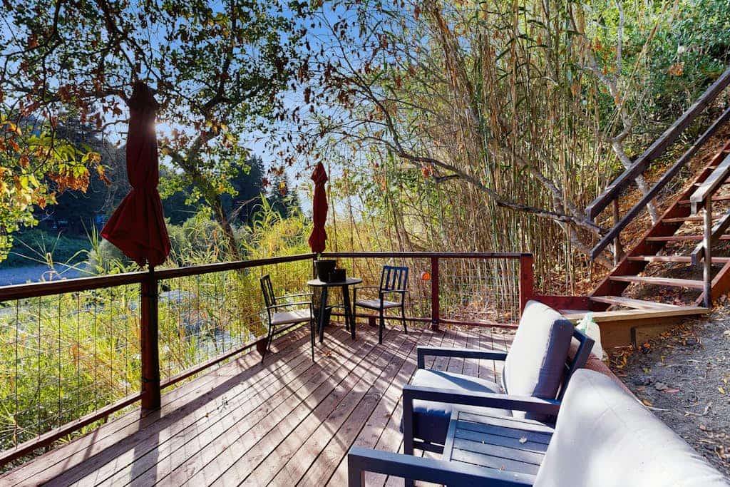 Step onto your private dock and watch the Russian River slide past while oak-covered hillsides frame the view. Two stacked units — each with its own entrance, patio, and bathroom — make this riverfront stay work for two couples or a family of four. A bocce court, big yard, and canoe wait outside, and downtown Healdsburg's wineries and fine dining are 2.4 miles away.