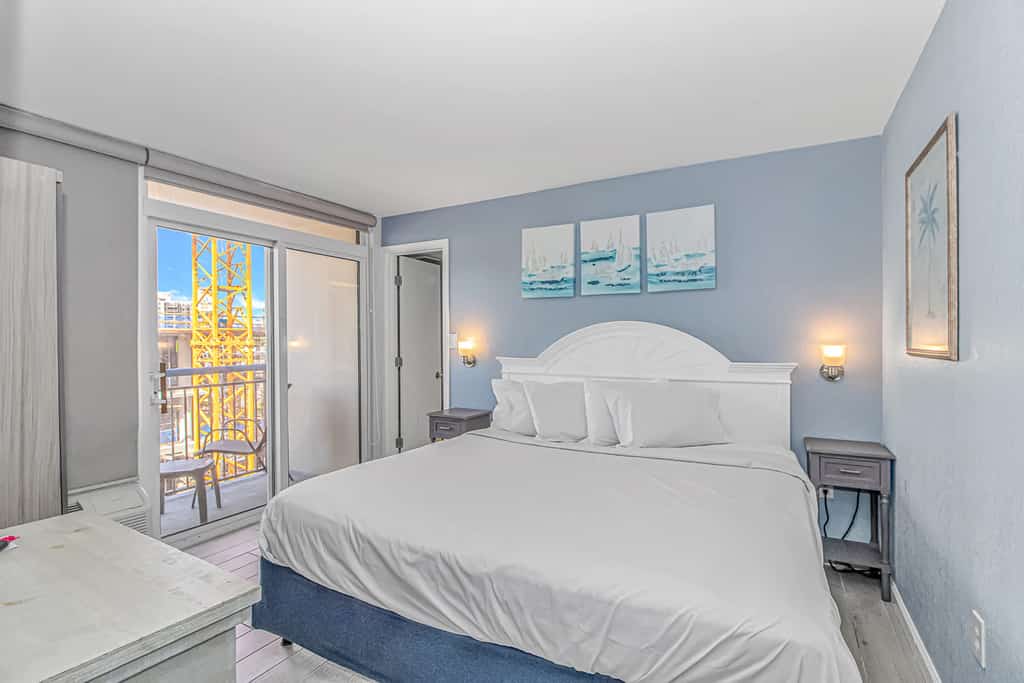 Check out this direct ocean view vacation rental at Boardwalk Resort in Myrtle Beach, SC. This ocean view vacation rental is fully furnished with everything you need for your next vacation. This apartment features 1 king bed and will comfortably accommodate 2 guests. This rental is a studio condo which means that it's basically the size of a hotel room. The living space consists of 1 king bed, multiple dressers for storage, wardrobe closet, Smart TV with basic cable, mini kitchenette, AC and Heat unit, a private balcony, and a private full-size bathroom. The bathroom features a tub/shower, granite countertop, new faucet, new vanity, and toilet. Our guests love having access to their own private balcony in the bedroom.