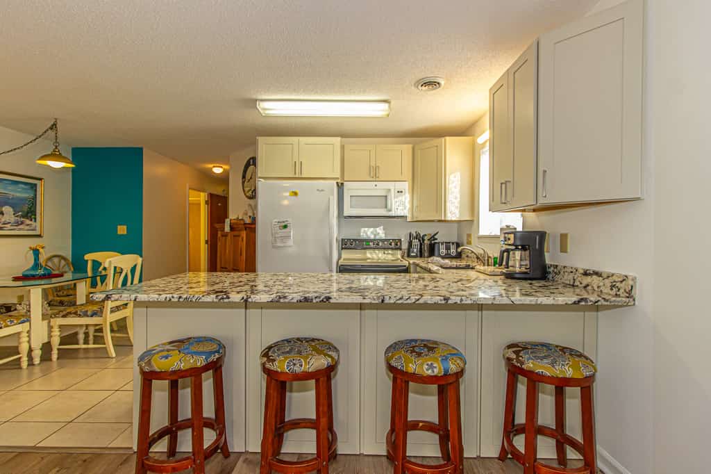 Check out this 2 bedroom, 2 bath rental located at Golf Colony behind Plantation Resort! This hidden gem sits on the ground level, making access a breeze. No stairs and no elevators! Located in the South Myrtle Beach / Surfside area, this location offers a break from the tourists and traffic but is only 10 minutes to downtown Myrtle Beach, and only 2 miles to the ocean. Have a large group? Rent this unit AND another just a block away.

As of Fall 2021, we have made a few updates to the property! The living room carpet has been removed and new laminate flooring has been installed. We have also updated the kitchen cabinets and installed new granite countertops. These updates have really made a huge difference, and our guests seem to appreciate these renovations!

This property will accommodate 6 guests comfortably and consists of approximately 800 sq ft. of living space. Once inside the apartment, guests will find a queen bed in the first bedroom on the left. This room does have a closet for storage, TV, and nightstand.

Minimum Night Stay Requirement: 7 night minimum stay required per the HOA

All guests should park in the overflow parking lots. We have included a photo of the parking map in the listing.