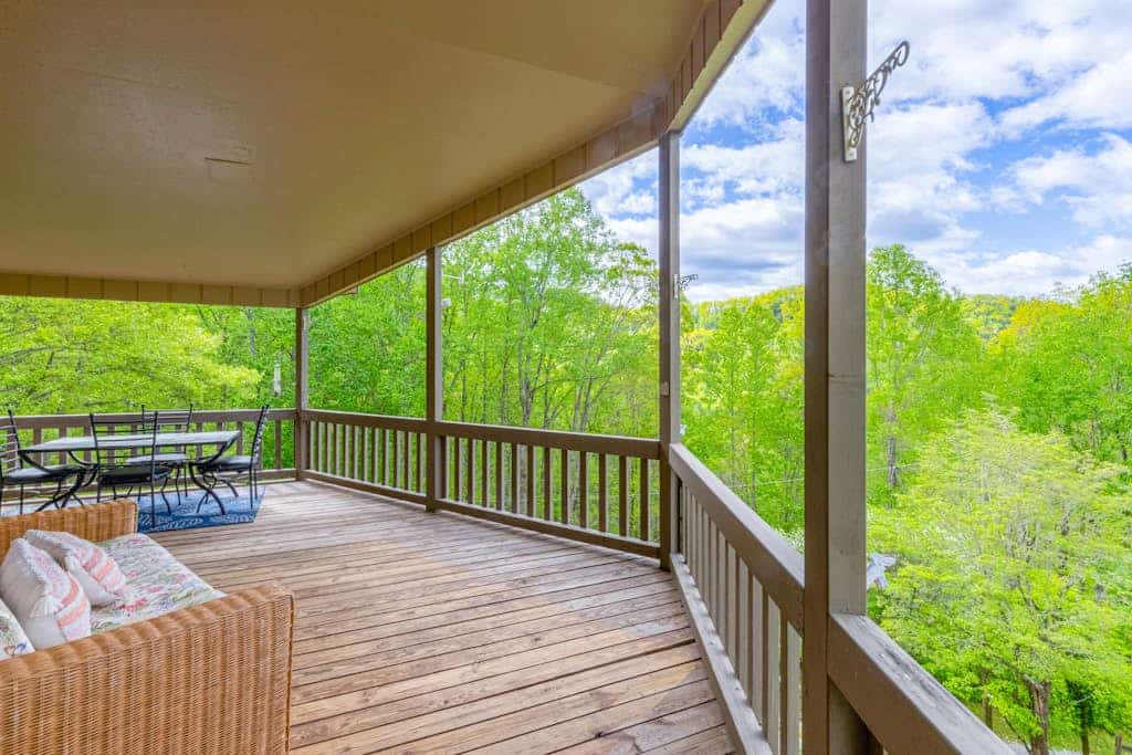 View-worthy home lined by trees with a fireplace, wrap-around deck, grill, & W/D