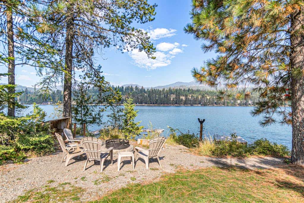Riverfront ranch with large deck, fire pit, dock, W/D, & mountain view