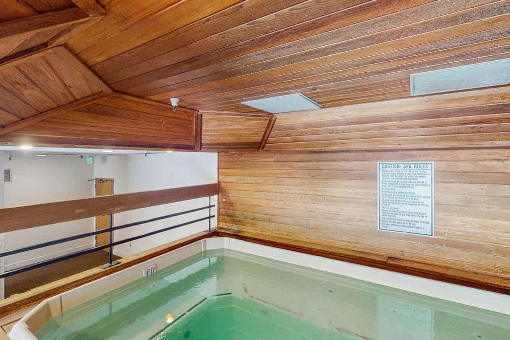 Charming condo with a private sunroom, kitchen, & hot tub - walk to lift