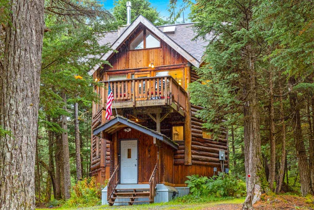 Ullr is the Norse god of snow, and his treehouse is exactly what it sounds like—a highly unique, 1,400 sq. ft. hexagonal cabin that climbs straight up into the spruce canopy across four distinct, 350 sq. ft. levels. Bordering Chugach State Park land, the back path connects you to Beaver Pond Trail for foot treks into town. The layout rises into the trees to offer intimate, custom spaces: a basement media room with a PS4, a second-floor leather lounge and compact kitchen, and a lofted primary bedroom under sloped timbers. Outside, a massive hot tub waits beneath the old-growth tree canopy. *Just be ready to summon your inner mountain goat for the four flights of stairs.* Standard Specs: Full compact kitchen, outdoor hot tub, gas fireplace, private washer/dryer, PS4 console, flat-screen TVs, high-speed WiFi, and keypad entry. Driveway parking for up to four vehicles. On the Glacier Valley Transit route. Sleeps 6.