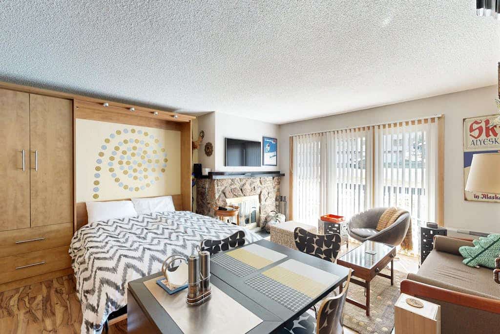 A clean, well-built studio condo that gets the mountain basics exactly right, eliminating logistical friction from your stay. Located within an easy walk of the main Alyeska Resort lifts, the ground-floor property places you under a mile from Girdwood Town Square's restaurants, shops, and libraries. The layout features a rare, full kitchen equipped with complete cookware for real meal prep, a comfortable living zone, and a private back patio pointing up at clear mountain views. Perfect for couples or solo travelers who want an uncomplicated mountain operational hub. Standard Specs: Full kitchen, private mountain-view patio, flat-screen TV, high-speed WiFi, and keypad entry. Dedicated parking for one vehicle. Under a mile to Town Square; Anchorage is a scenic 41-mile drive. Sleeps 2.