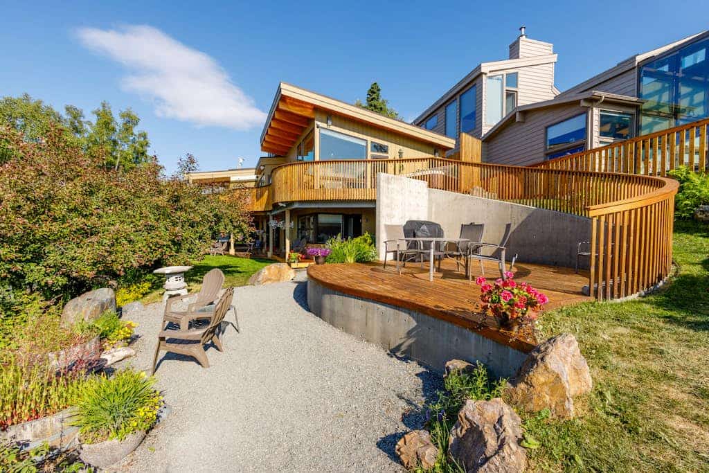 Featured in Alaska's Best Kitchens Magazine—and earning every bit of the title. A solid redwood island, a pro Miele cooktop, a steam oven, a convection oven, and dual dishwashers anchor the kitchen of this premium upper-level Anchorage triplex, turning meal prep into a highlight of the trip rather than a chore. The expansive views continue through the living spaces, framing the waters of Cook Inlet and Sleeping Lady. Step outside into a shared park-like garden retreat to fire up the deluxe gas grill, dine alfresco, or soak in your private hot tub. Includes independent home office nooks in each bedroom for seamless remote work and a tranquil downstairs sunroom. Standard Specs: Award-winning chef's kitchen, private outdoor hot tub, shared landscaped gardens with gas grill, dual remote work office nooks, flat-screen TV, high-speed WiFi, and keypad entry. Designated driveway parking for one vehicle. Fireplace is decorative only. Sleeps 8.