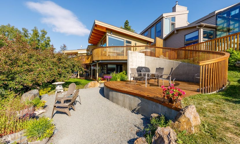 Featured in Alaska's Best Kitchens Magazine—and earning every bit of the title. A solid redwood island, a pro Miele cooktop, a steam oven, a convection oven, and dual dishwashers anchor the kitchen of this premium upper-level Anchorage triplex, turning meal prep into a highlight of the trip rather than a chore. The expansive views continue through the living spaces, framing the waters of Cook Inlet and Sleeping Lady. Step outside into a shared park-like garden retreat to fire up the deluxe gas grill, dine alfresco, or soak in your private hot tub. Includes independent home office nooks in each bedroom for seamless remote work and a tranquil downstairs sunroom. Standard Specs: Award-winning chef's kitchen, private outdoor hot tub, shared landscaped gardens with gas grill, dual remote work office nooks, flat-screen TV, high-speed WiFi, and keypad entry. Designated driveway parking for one vehicle. Fireplace is decorative only. Sleeps 8.